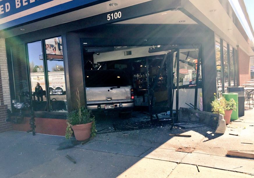 Vehicle crashes through deli on Colfax