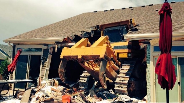 Bulldozer drives into house