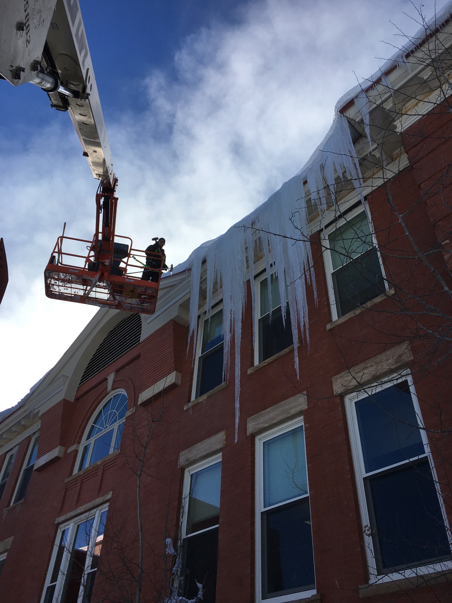 Crews work to remove snow, giant icicles
